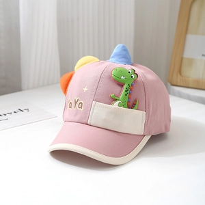 Detail der rosa Baby-Kappe aus Baumwolle mit 3D-Dinosaurier-Stickerei und bunten Zacken