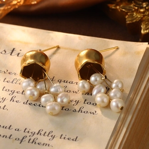 Detailed macro of vintage style golden bell earrings with multiple small white pearls