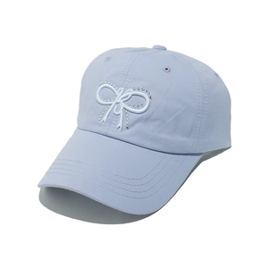 Detail of light blue baseball cap featuring a white embroidered bow with sparkling rhinestones
