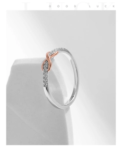 Macro shot of silver Mobius ring with rose gold accents and pavé diamond detailing