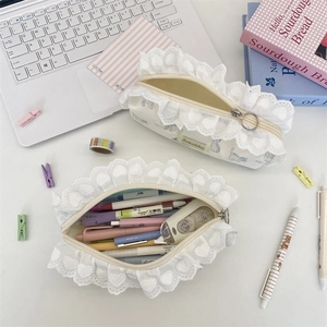 Close-up of white canvas pencil case featuring heart lace trim and blue animal print