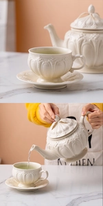 Close-up of embossed ceramic tea set with ivory relief detail and tea pouring scene