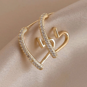 Elegant gold-plated heart hoop earrings with cubic zirconia on soft beige silk background