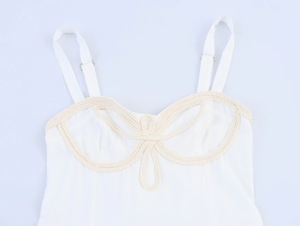 Close-up of white dress bodice with beige rope-knot texture and adjustable metal buckle
