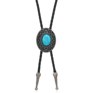 Macro detail of vintage bolo tie pendant with turquoise stone and enamel floral accents