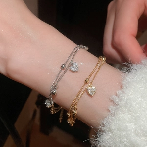 Detailed view of layered 18k gold plated heart bracelets with sparkling zirconia stones