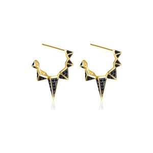 Close-up of gold-plated spiked geometric hoop earrings with black pavé diamonds