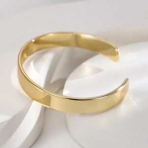 Minimalist gold-plated brass open C-shape adjustable cuff bracelet on stone background