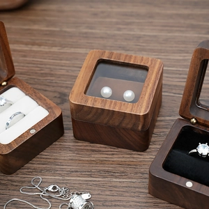 Macro view of walnut wood ring box with white velvet lining and magnetic closure
