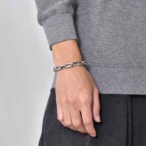 Detail of silver stainless steel paperclip chain bracelet worn on a female wrist