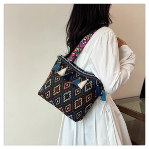 Detail of woven crossbody bag with colorful geometric patterns and decorative tassels