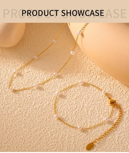 Detail of gold-plated titanium necklace and bracelet set with white faux pearls