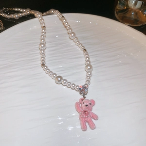 Detail of pearl necklace with pink flocked teddy bear pendant and sparkling rhinestones