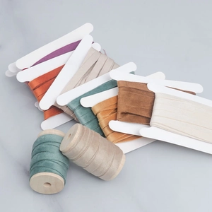 Detail of colorful velvet ribbons on wooden spools with soft texture for DIY crafts