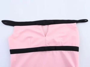 Dettaglio del top rosa con fiocchi neri, spalline sottili e tessuto dalla trama ruvida