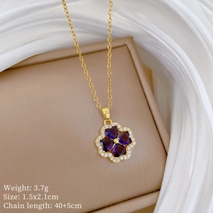 Detail of flower pendant with purple heart stones and gold chain on jewelry box