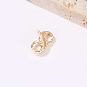 Close-up of polished 14k gold plated double-ended lobster clasp for jewelry DIY