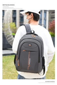 Detail of grey outdoor backpack with orange zippers and side mesh bottle pocket
