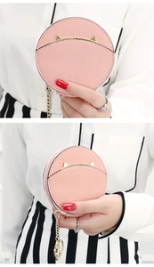 Detailed view of pink leather coin purse featuring gold cat ear metal accents and chain