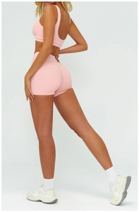 Détail du short rose taille haute effet galbant et dos du débardeur de sport