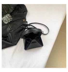 Macro view of a black geometric crossbody bag featuring punk-style triangular 3D structure