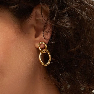 Elegant gold double link chain earrings featuring high-polish finish on a female model