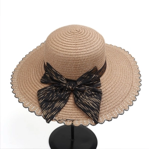 Close-up of the scalloped lace edge and metallic striped bow on this summer straw sun hat