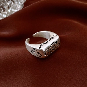 Detail of vintage silver open ring featuring an engraved horse motif on a red silk background