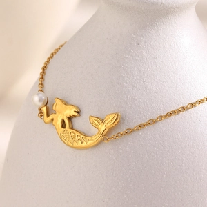 Bracelet en acier inoxydable doré 18K avec pendentif sirène et perle sur vase blanc