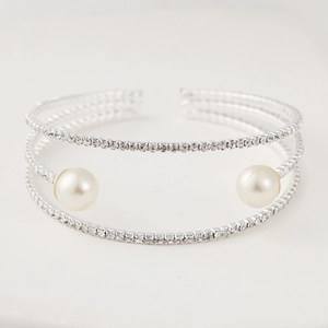 Close-up of triple-layered silver bracelet with sparkling rhinestones and white pearls