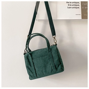 Detail of green corduroy Boston bag with adjustable strap and dual handles