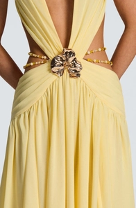 Detail of light yellow dress with 3D gold metal flower and beaded chain waist cut-out