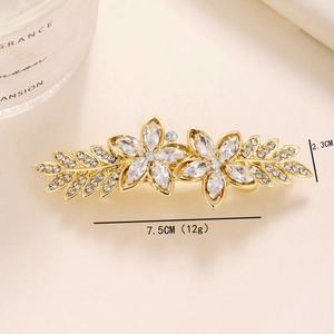 Detail view of a gold floral hair clip with crystal inlay and 7.5cm size dimensions