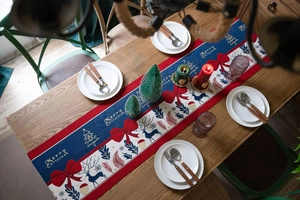 Detailed close-up of festive jacquard table runner with reindeer and Merry Christmas patterns