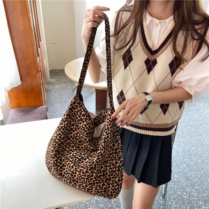 Detailed view of a trendy large capacity leopard print canvas tote bag on a model