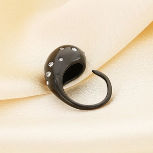 Detail of water drop ring in black finish with white crystals on silk background