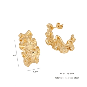 Detail view of gold irregular wavy earrings with measurements 3cm by 1.5cm on white background