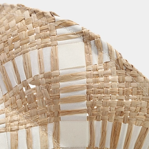 Close-up of natural straw weaving pattern and white ribbon detail on summer sun hat