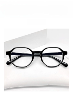 Close-up of stylish black hexagonal full-rim glasses frame on a minimalist white case