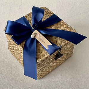 Detail of square woven gift basket with elegant navy ribbon and Thank You tag