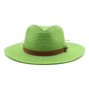 Detail view of woven green Panama hat with brown leather band and silver buckle