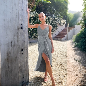 Détail de robe d'été grise en soie avec nœud à la taille et fente latérale dans un jardin