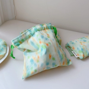 Detail view of colorful watercolor drawstring storage bag with a fabric logo label