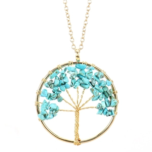 Detail of tree of life pendant with handmade gold wire wrap and turquoise crystal stones