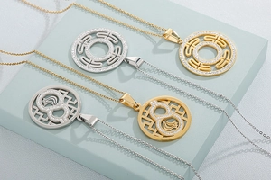 Detailed macro view of gold and silver gourd-shaped stainless steel necklaces with zircon