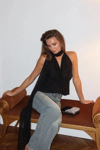 Detailansicht des eleganten schwarzen Neckholder-Tops mit edlem Satin-Drapierungseffekt