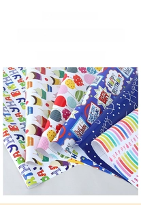 Close-up of birthday gift wrapping paper with rainbow, balloon and cupcake patterns