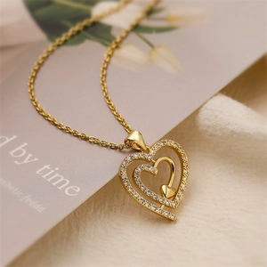 Vue détaillée d'un collier pendentif cœur doré serti de pierres de zircon blanc