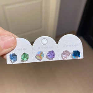 Close-up of 3 pairs of cube-cut crystal stud earrings in 6 vibrant colors on card