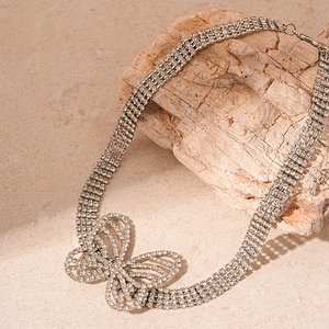 Elegant silver butterfly necklace with multi-row rhinestones on a natural stone surface